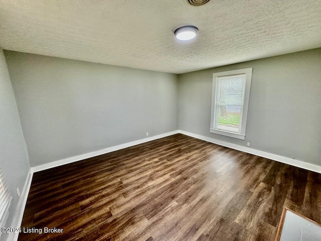 unfurnished room featuring dark hardwood / wood-style floors and a textured ceiling