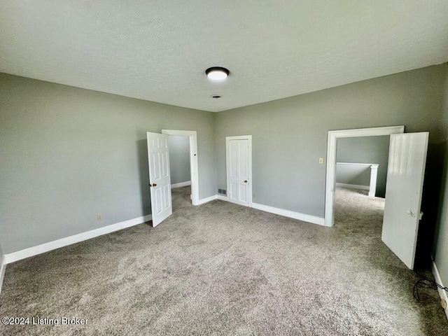 unfurnished bedroom with carpet floors and a textured ceiling