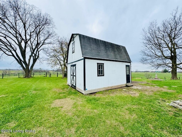 view of outdoor structure with a rural view and a yard