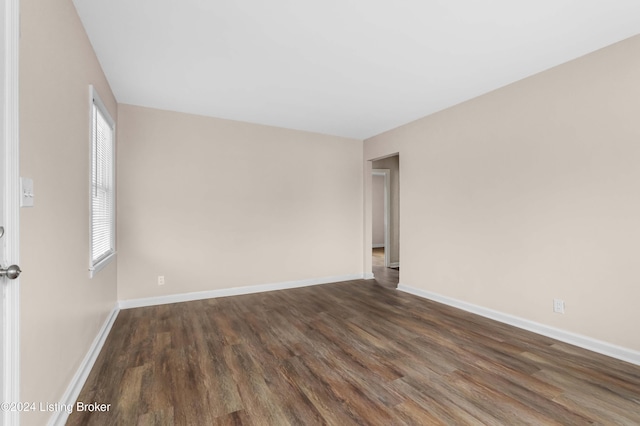 unfurnished room with dark wood-type flooring