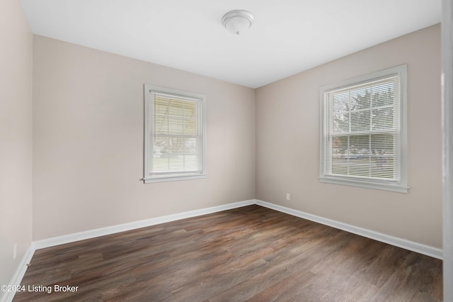 empty room with dark wood-type flooring and a healthy amount of sunlight