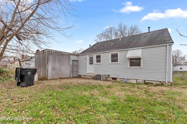 rear view of house featuring a yard and central AC unit