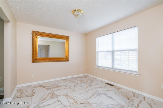 spare room with a textured ceiling