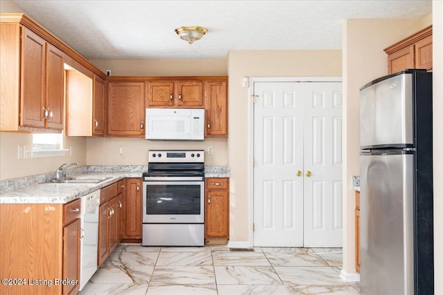 kitchen with sink, stainless steel appliances, and a textured ceiling