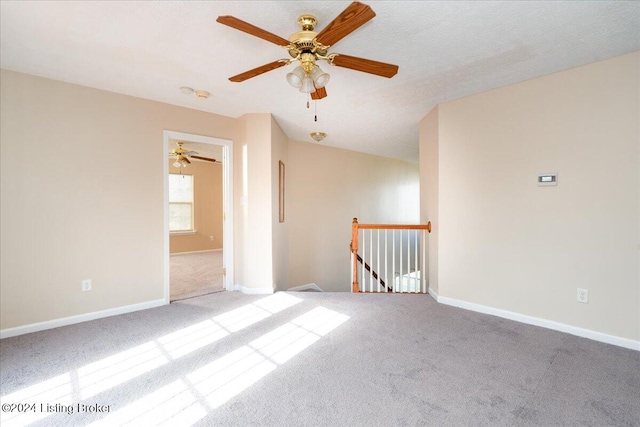 spare room with ceiling fan, light colored carpet, and a textured ceiling