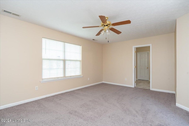 spare room featuring ceiling fan and light colored carpet