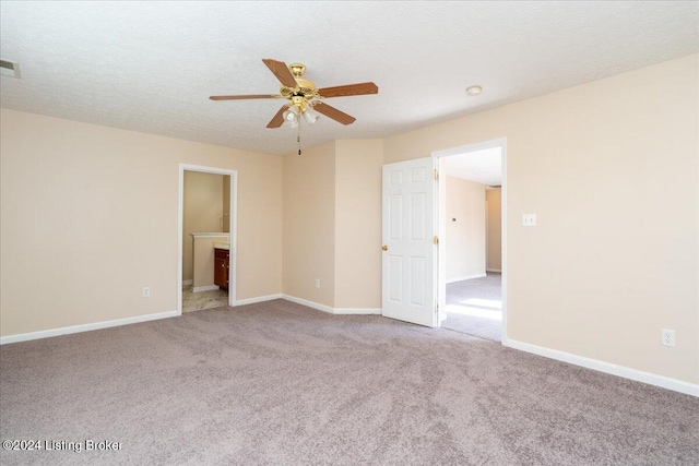 carpeted spare room featuring ceiling fan and a textured ceiling