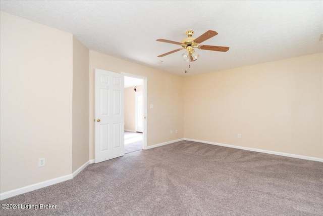 carpeted empty room featuring ceiling fan and a textured ceiling