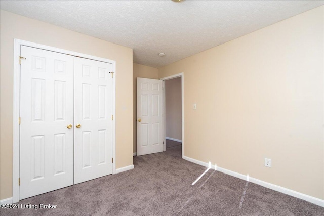 unfurnished bedroom with carpet flooring, a textured ceiling, and a closet