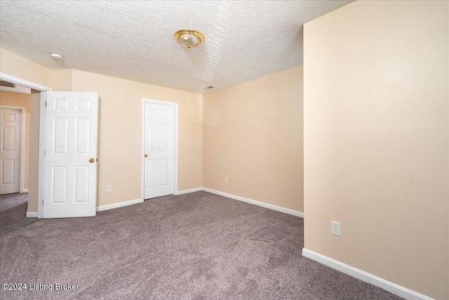 carpeted empty room with a textured ceiling