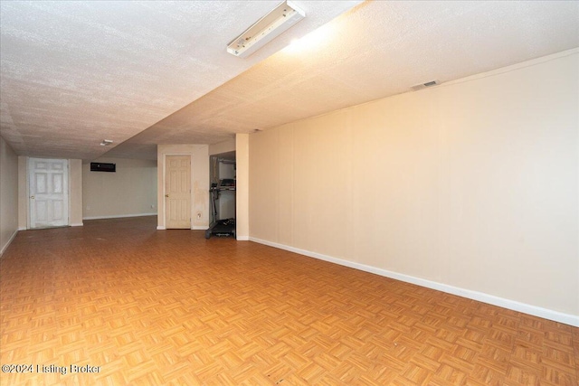 empty room with a textured ceiling and light parquet flooring