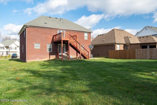 rear view of property featuring a yard and a deck