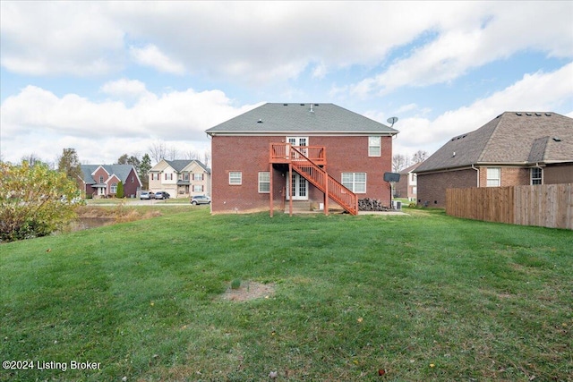 rear view of house with a deck and a lawn