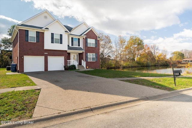 view of front facade with a front yard, a water view, and a garage