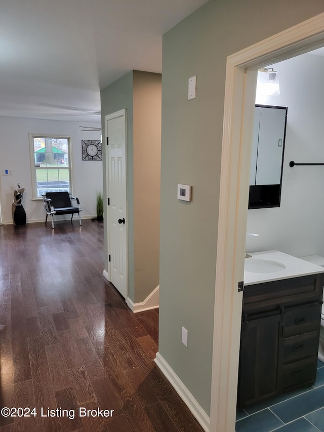 corridor with dark hardwood / wood-style flooring and sink