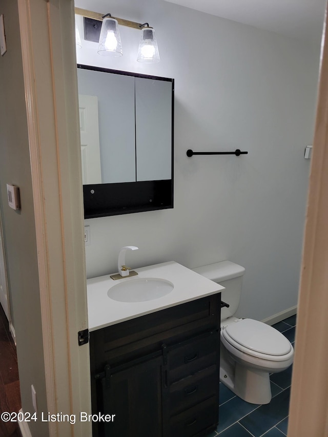 bathroom featuring tile patterned floors, vanity, and toilet