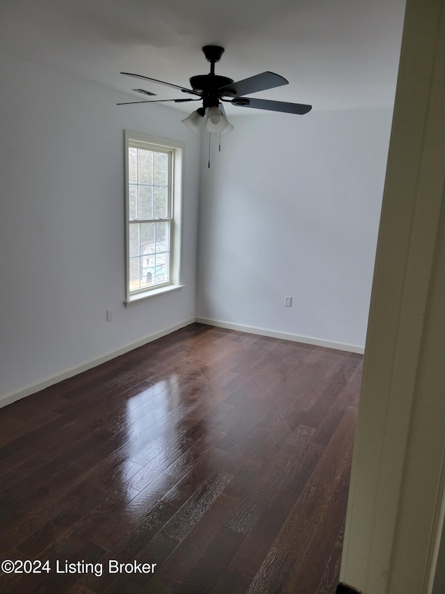 spare room featuring ceiling fan and dark wood-type flooring