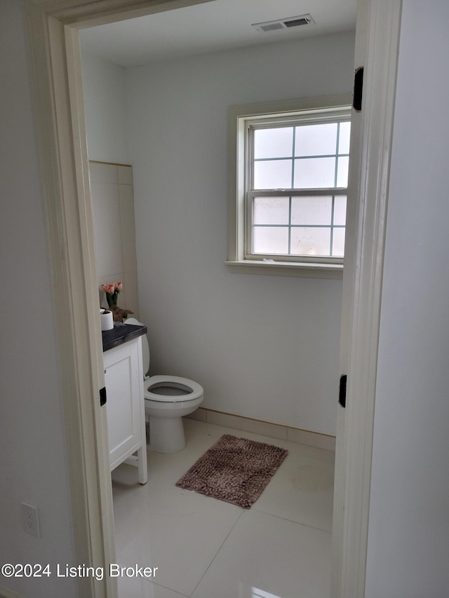 bathroom featuring tile patterned flooring, vanity, and toilet