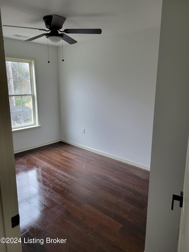 spare room with ceiling fan and dark wood-type flooring