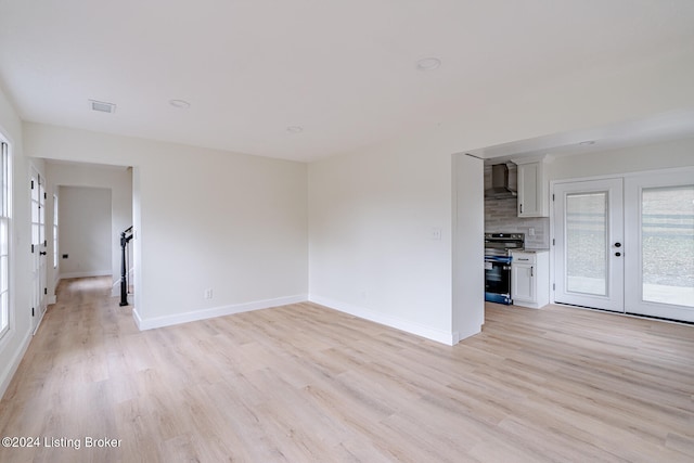 unfurnished living room featuring french doors and light hardwood / wood-style floors