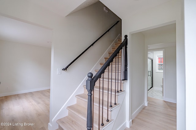 stairs featuring hardwood / wood-style floors