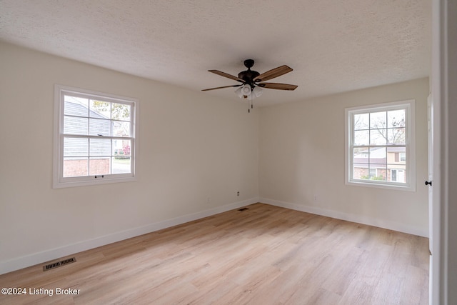 spare room with ceiling fan, light hardwood / wood-style floors, and a textured ceiling