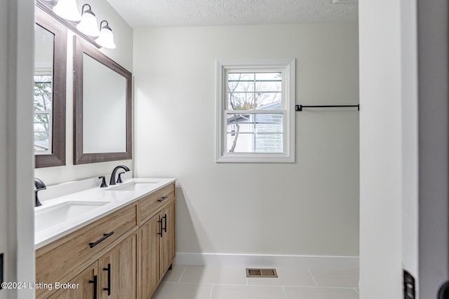 bathroom featuring tile patterned floors, vanity, and a textured ceiling