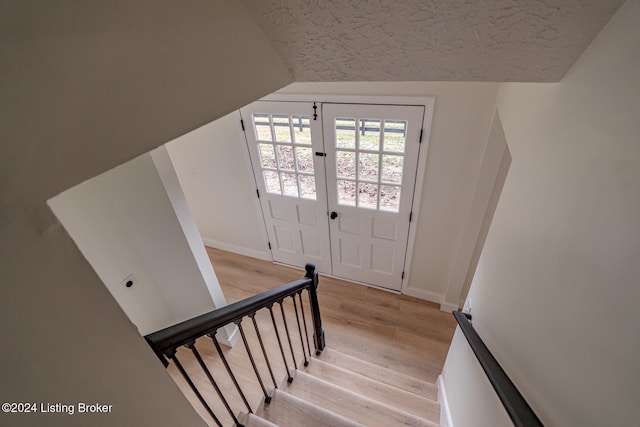 stairs featuring hardwood / wood-style floors and lofted ceiling