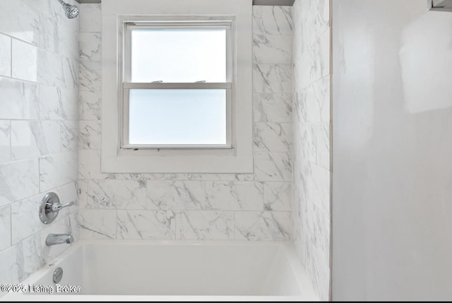 bathroom with tiled shower / bath combo and a healthy amount of sunlight