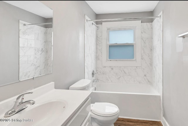 full bathroom featuring wood-type flooring, toilet, vanity, and tiled shower / bath