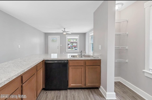 kitchen featuring ceiling fan, dishwasher, kitchen peninsula, sink, and light wood-type flooring