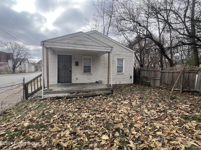 rear view of property featuring covered porch