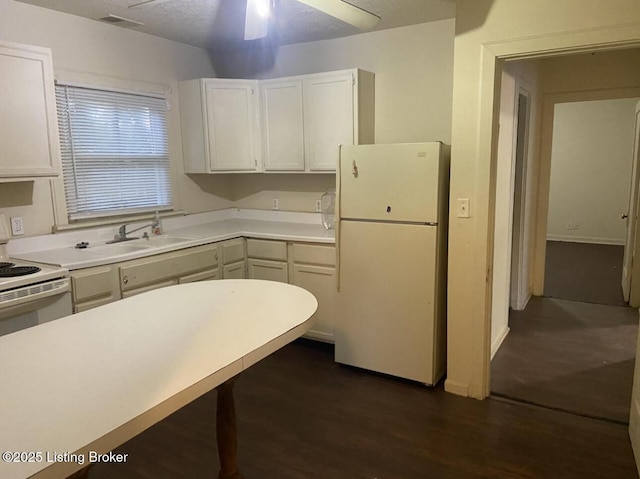 kitchen featuring dark hardwood / wood-style flooring, ceiling fan, white cabinets, and white appliances