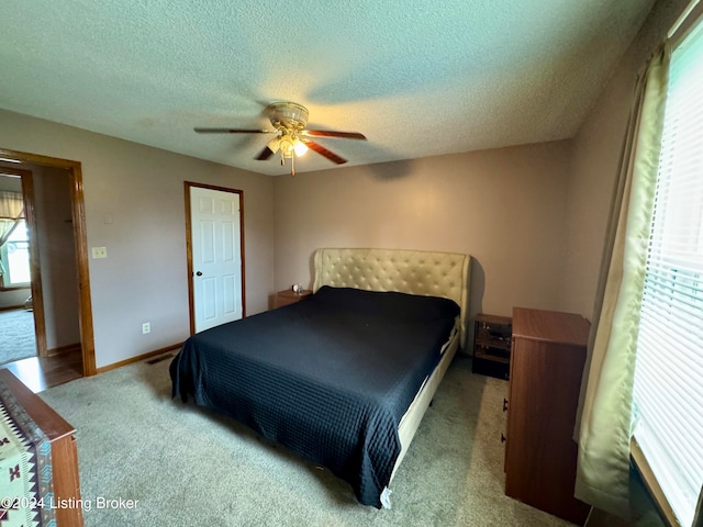 bedroom featuring carpet, ceiling fan, and a textured ceiling