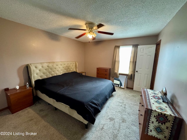 bedroom featuring ceiling fan, light colored carpet, and a textured ceiling