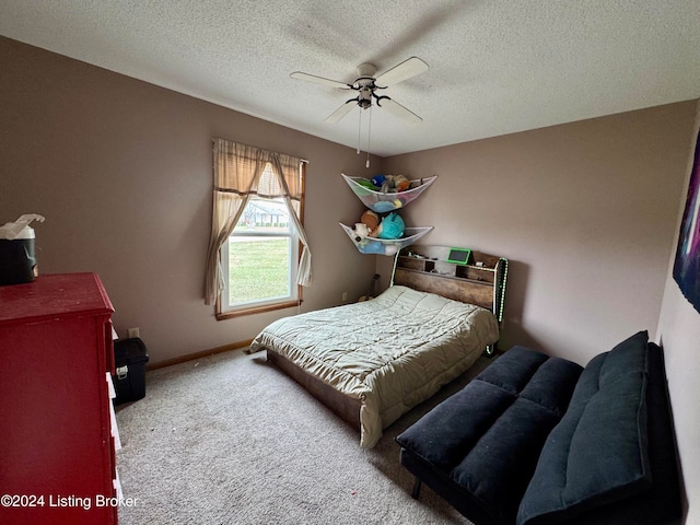 bedroom with ceiling fan, carpet floors, and a textured ceiling