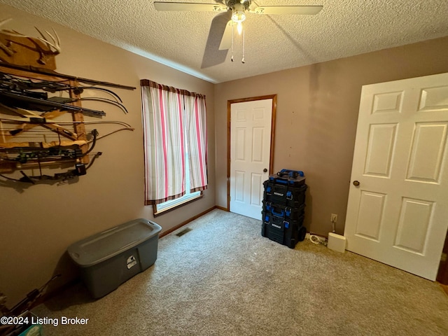 misc room with ceiling fan, carpet floors, and a textured ceiling