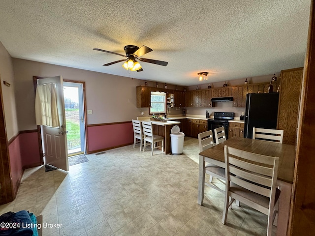 kitchen with a textured ceiling, ceiling fan, black appliances, and extractor fan