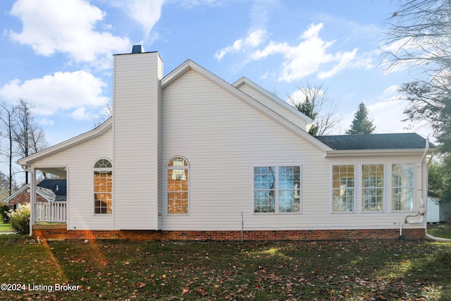 view of side of home with a yard