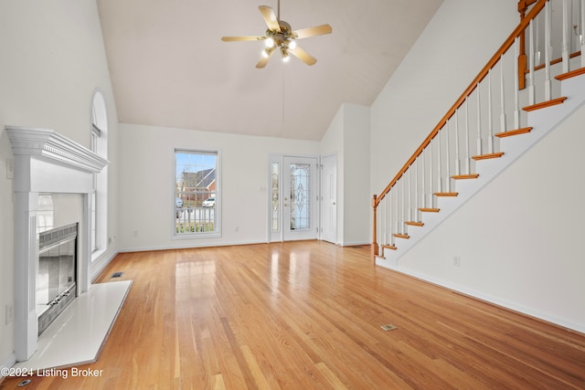 unfurnished living room with ceiling fan, light hardwood / wood-style flooring, and high vaulted ceiling