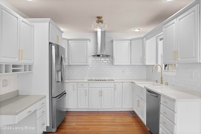 kitchen featuring wall chimney exhaust hood, white cabinetry, and stainless steel appliances