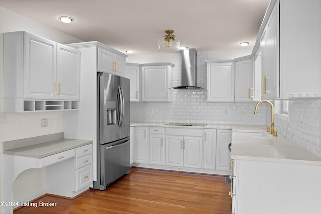 kitchen featuring white cabinets, stainless steel refrigerator with ice dispenser, wall chimney exhaust hood, and sink