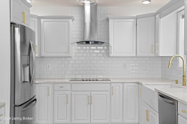 kitchen featuring tasteful backsplash, white cabinets, wall chimney exhaust hood, and stainless steel appliances