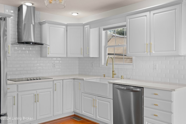 kitchen with dishwasher, sink, wall chimney range hood, light hardwood / wood-style flooring, and white cabinets