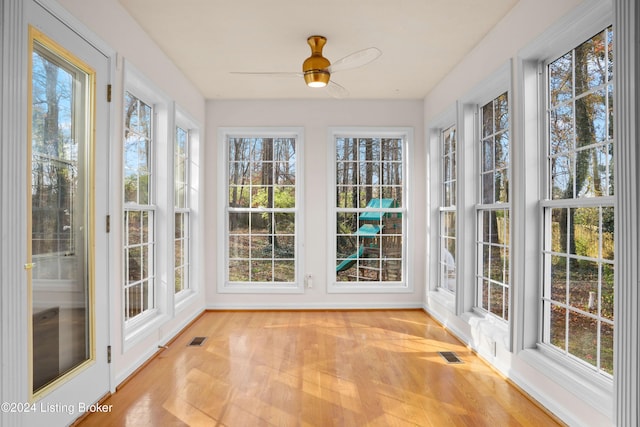 unfurnished sunroom featuring ceiling fan