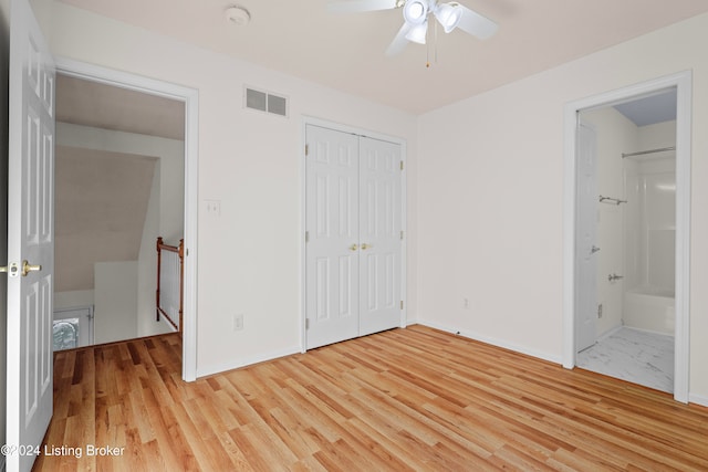 unfurnished bedroom with a closet, light hardwood / wood-style floors, ceiling fan, and ensuite bathroom