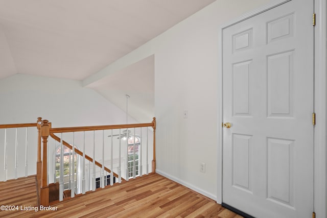 hall with hardwood / wood-style floors and vaulted ceiling with beams