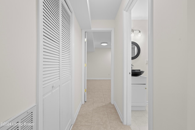 hallway with light tile patterned floors and sink