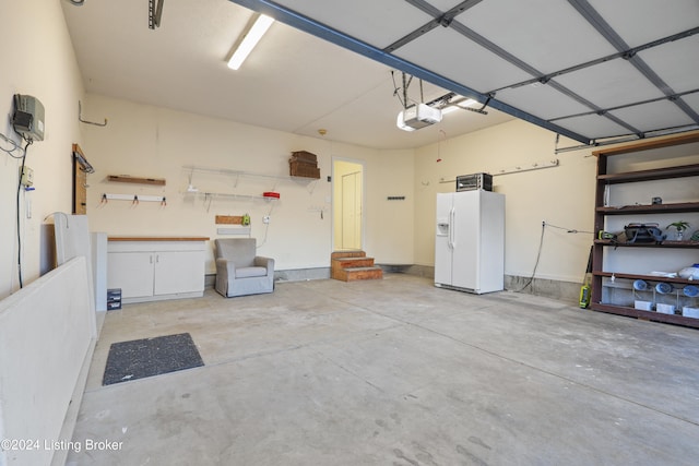 garage with white refrigerator with ice dispenser and a garage door opener