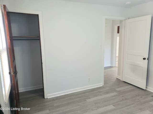 unfurnished bedroom featuring light hardwood / wood-style flooring and a closet